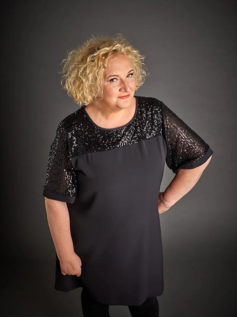 Maria Pia Timo in abito nero di paillettes, mano sul fianco
